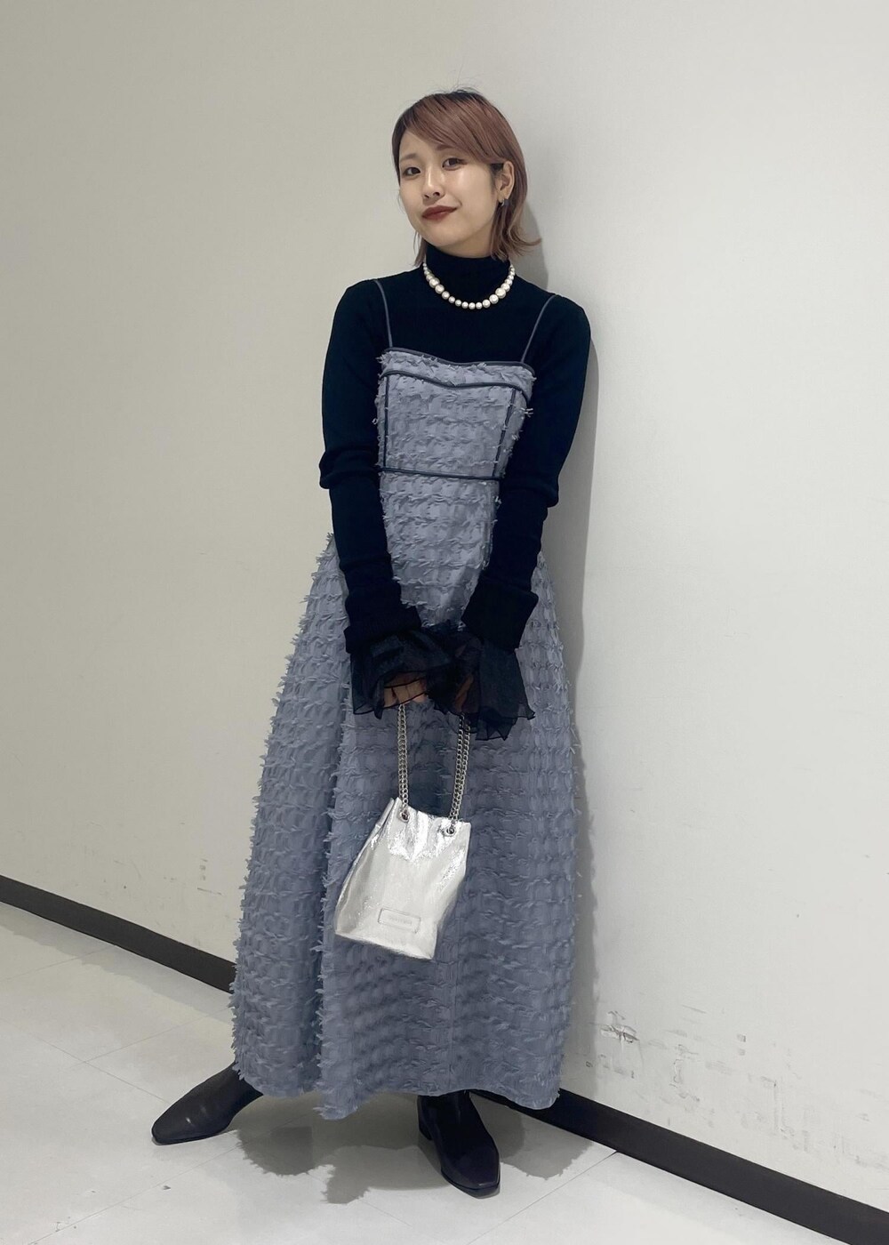 ブラウン系のブーツ、ブラック系のニット/セーター、ブラック系のネックレスを着用したレディースの冬コーディネートの2枚目の写真