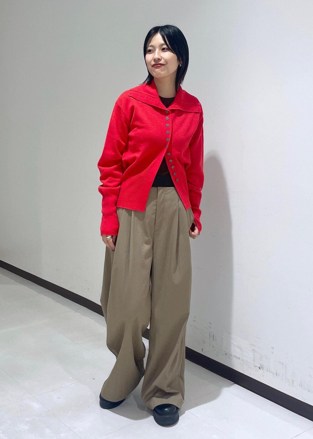 グリーン系のスラックス、ブラック系のサンダル、ブラウン系のTシャツ/カットソーを着用したレディースの秋コーディネートの2枚目の写真