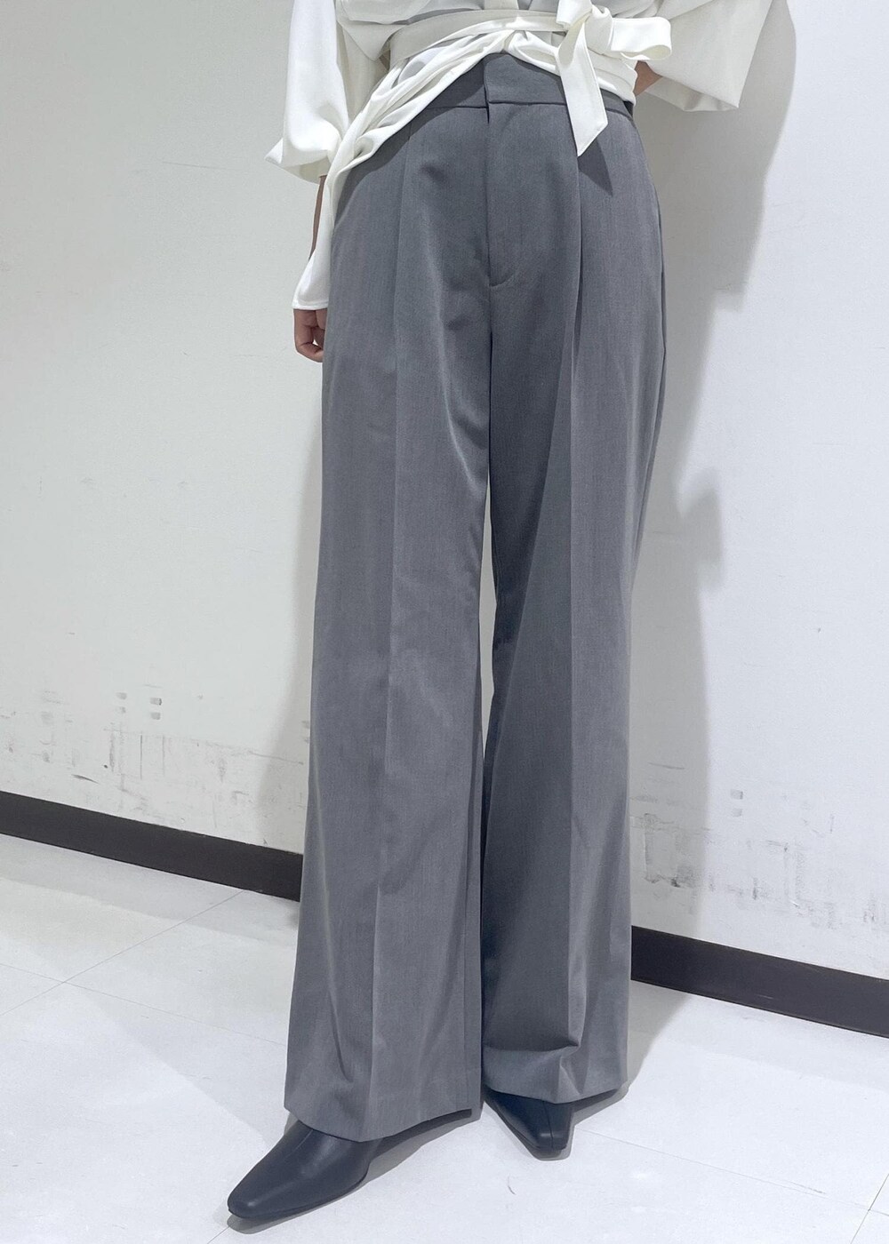 ホワイト系のシャツ/ブラウス、ホワイト系のショルダーバッグ、グレー系のスラックスを着用したレディースの夏コーディネートの8枚目の写真