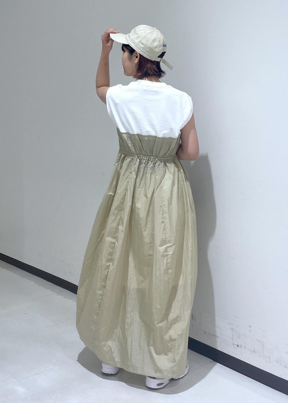 ブラウン系のハンドバッグ、ベージュ系のワンピース、ホワイト系のネックレスを着用したレディースの夏コーディネートの3枚目の写真