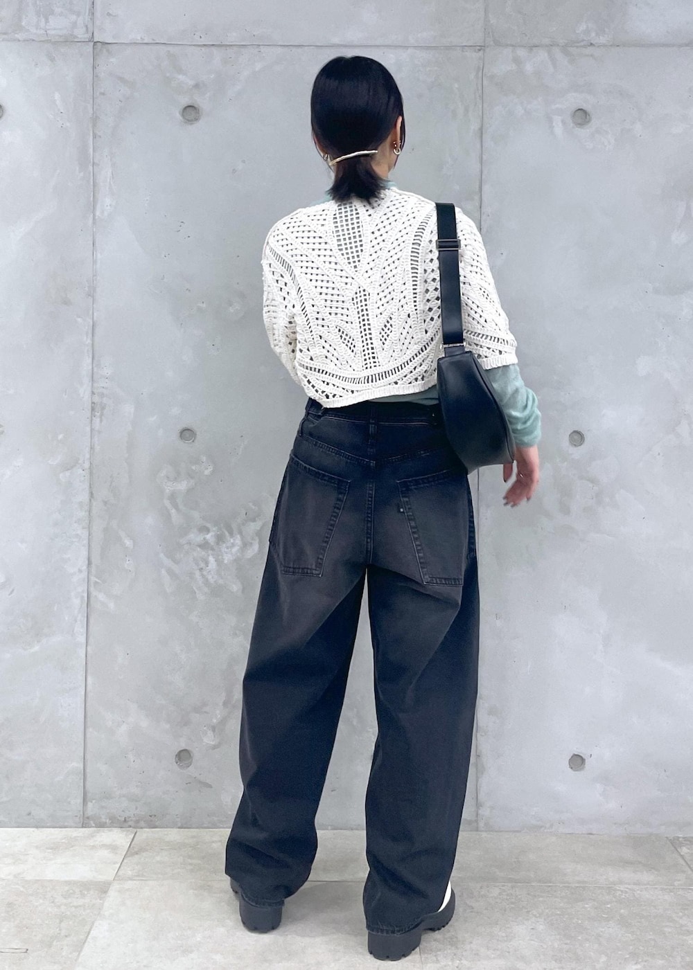 ホワイト系のローファー、グリーン系のニット/セーター、ブラック系のデニムパンツを着用したレディースの冬コーディネートの4枚目の写真