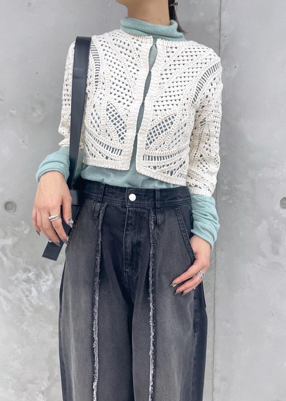 ホワイト系のローファー、グリーン系のニット/セーター、ブラック系のデニムパンツを着用したレディースの冬コーディネートの7枚目の写真