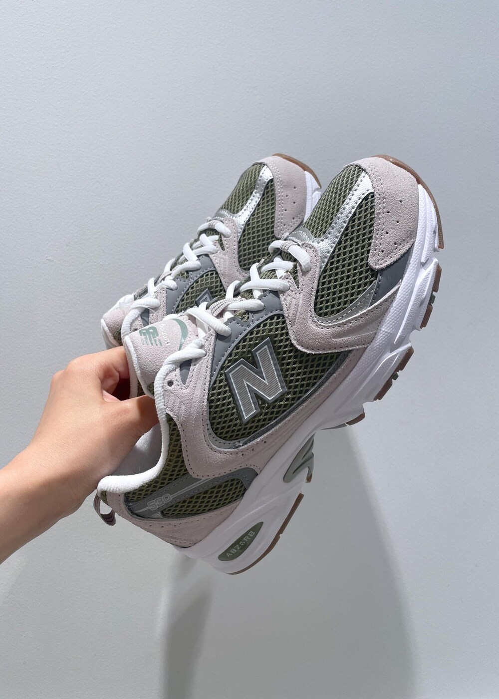 ブラウン系のハンドバッグ、ベージュ系のワンピース、ホワイト系のネックレスを着用したレディースの夏コーディネートの8枚目の写真