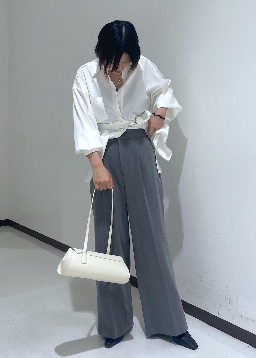 ホワイト系のシャツ/ブラウス、ホワイト系のショルダーバッグ、グレー系のスラックスを着用したレディースの夏コーディネートの7枚目の写真