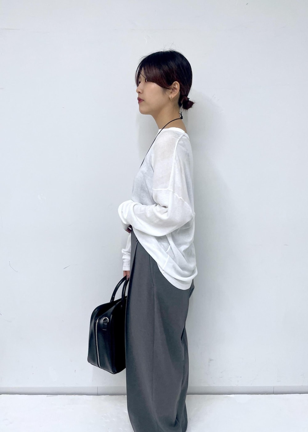 ブラック系のボストンバッグ、シルバー系のサンダル、ホワイト系のTシャツ/カットソーを着用したレディースの春コーディネートの6枚目の写真