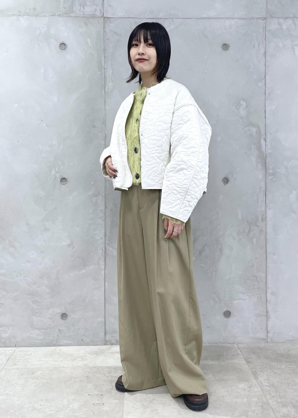 ブラウン系のローファー、グリーン系のカーディガン/ボレロ、グリーン系のスラックスを着用したレディースの冬コーディネートの2枚目の写真