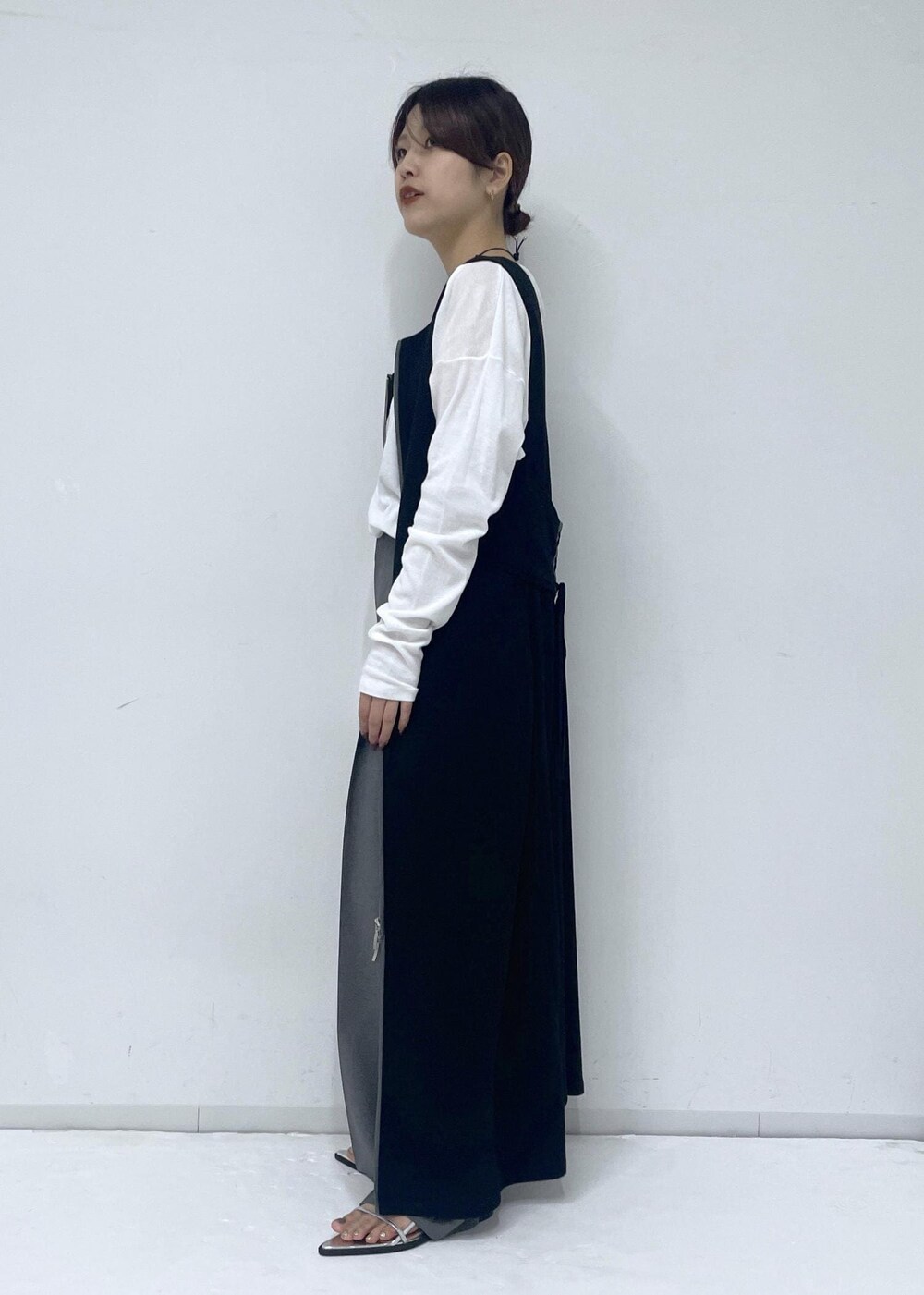 シルバー系のサンダル、ブラック系のワンピース、ホワイト系のTシャツ/カットソーを着用したレディースの春コーディネートの2枚目の写真