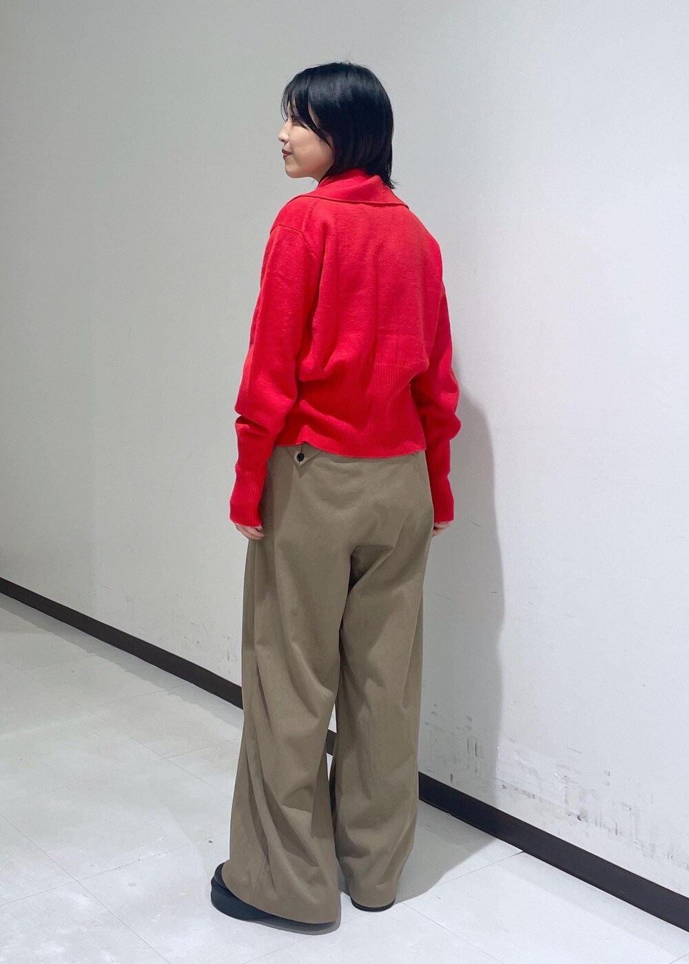 グリーン系のスラックス、ブラック系のサンダル、ブラウン系のTシャツ/カットソーを着用したレディースの秋コーディネートの3枚目の写真