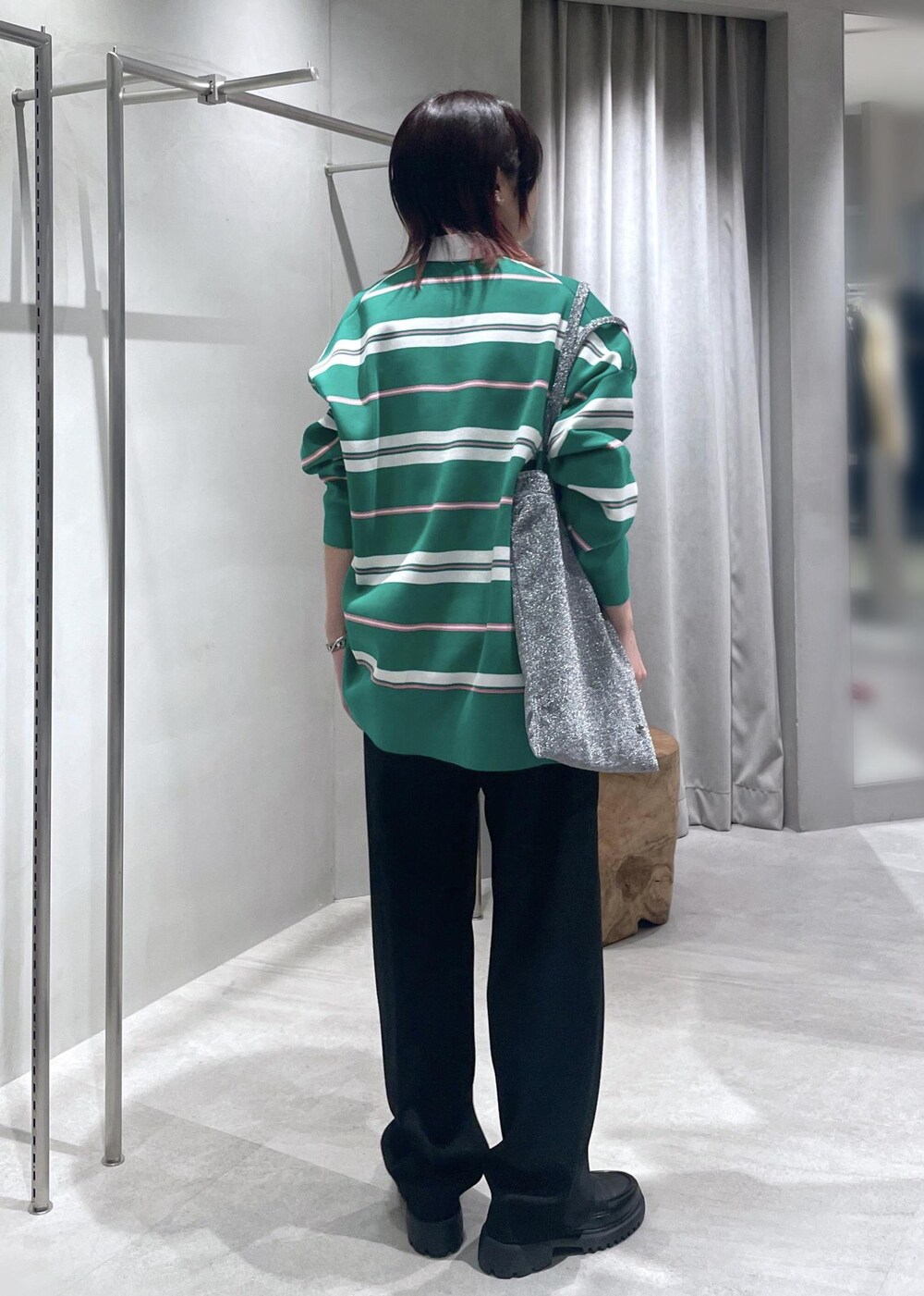 グリーン系のニット/セーター、ブラック系のスラックス、シルバー系のトートバッグを着用したレディースの冬コーディネートの4枚目の写真