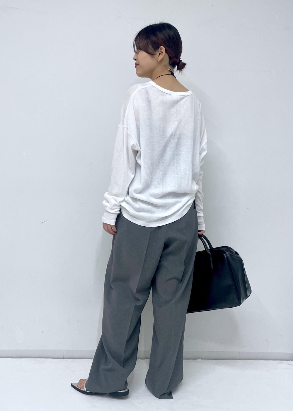 ブラック系のボストンバッグ、シルバー系のサンダル、ホワイト系のTシャツ/カットソーを着用したレディースの春コーディネートの4枚目の写真