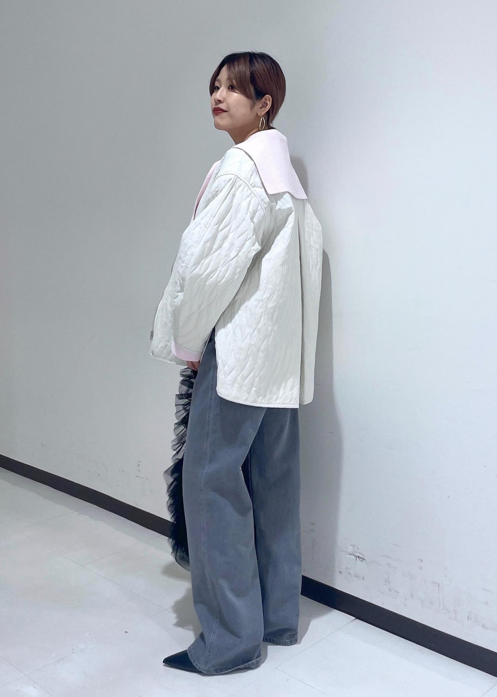 ホワイト系のブルゾンを着用したレディースの冬コーディネートの2枚目の写真