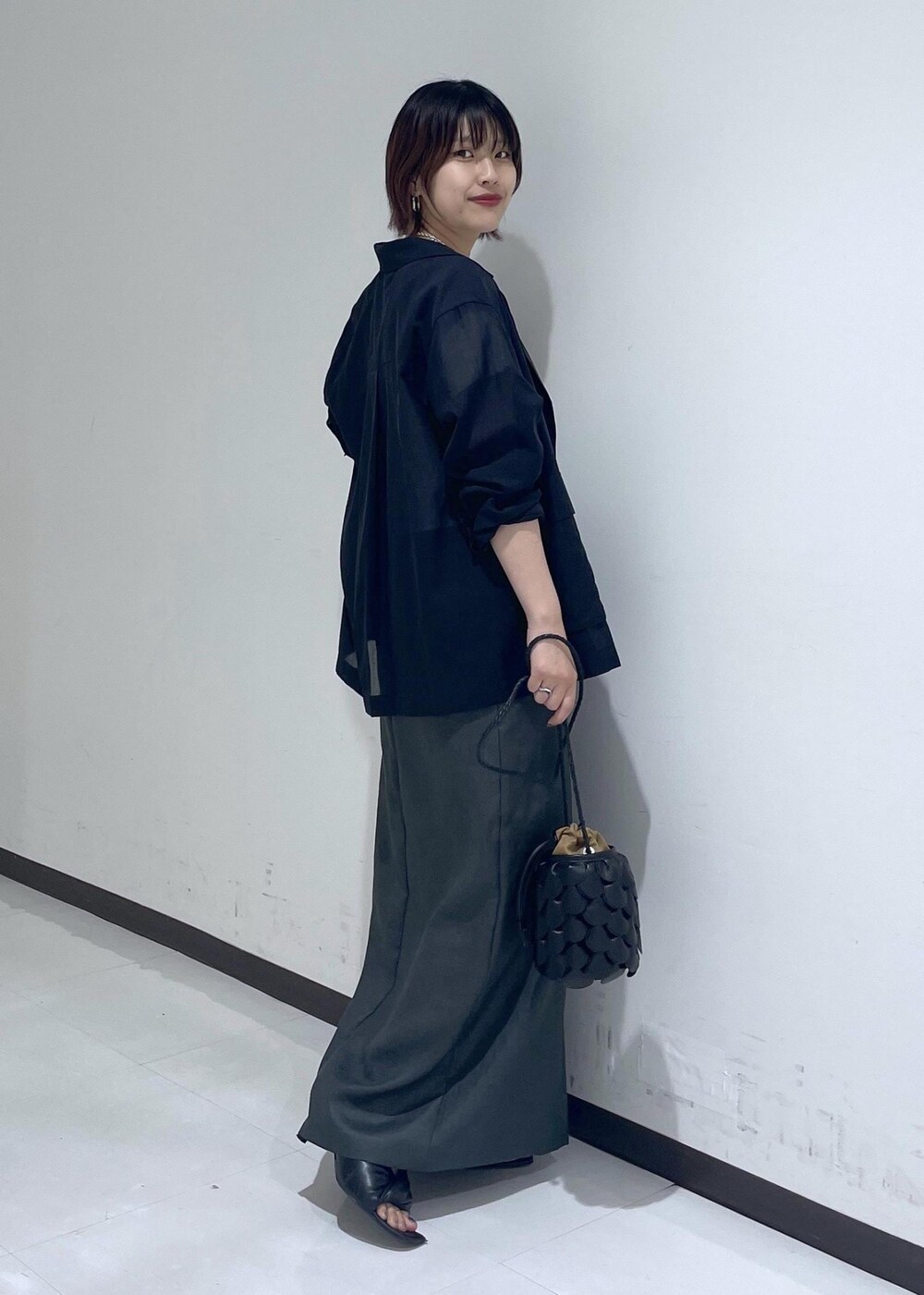 グレー系のスカート、ブラック系のテーラードジャケット、ホワイト系のTシャツ/カットソーを着用したレディースの夏コーディネートの4枚目の写真