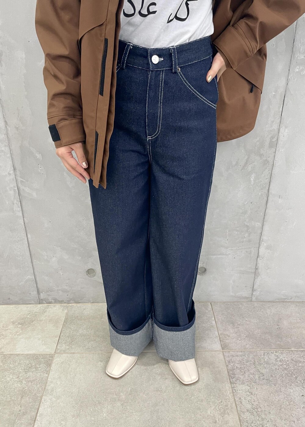 ホワイト系のTシャツ/カットソー、ブラウン系のマウンテンパーカー、ホワイト系のブーツを着用したレディースの夏コーディネートの6枚目の写真