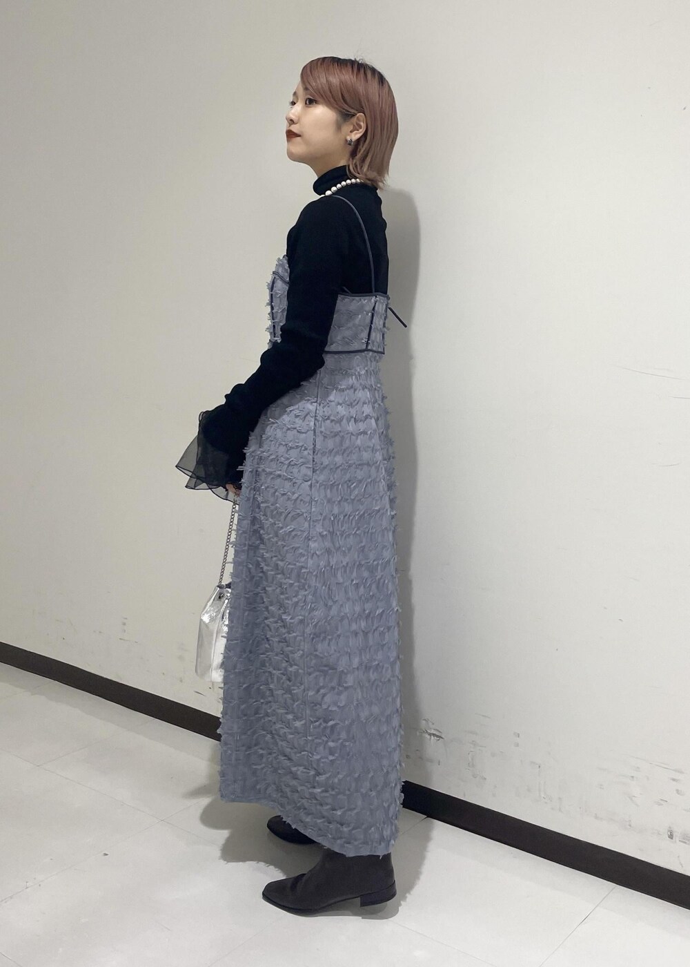 ブラウン系のブーツ、ブラック系のニット/セーター、ブラック系のネックレスを着用したレディースの冬コーディネートの3枚目の写真