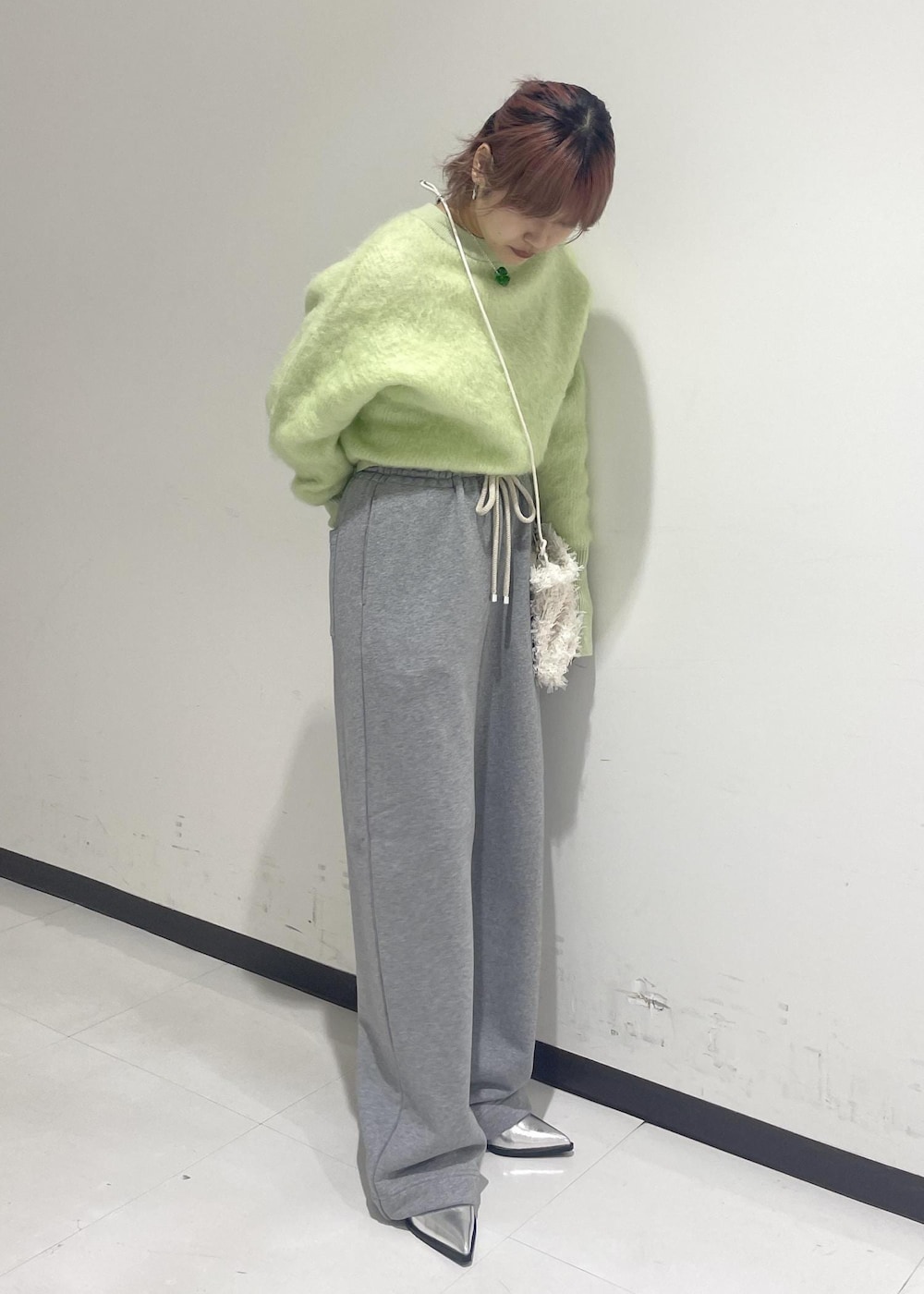 シルバー系のパンプス、グリーン系のニット/セーター、ホワイト系のショルダーバッグを着用したレディースの秋コーディネートの4枚目の写真