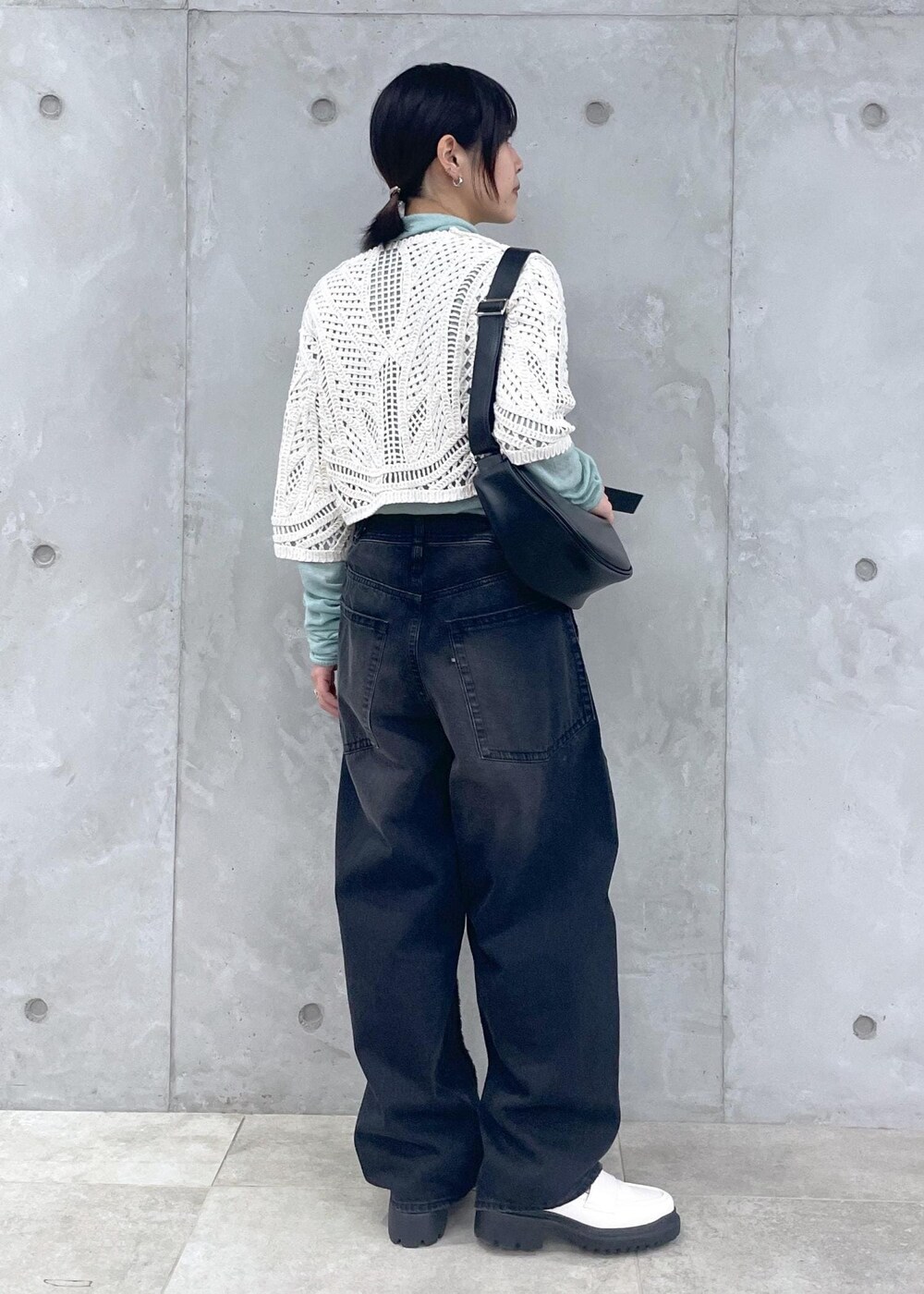 ホワイト系のローファー、グリーン系のニット/セーター、ブラック系のデニムパンツを着用したレディースの冬コーディネートの5枚目の写真