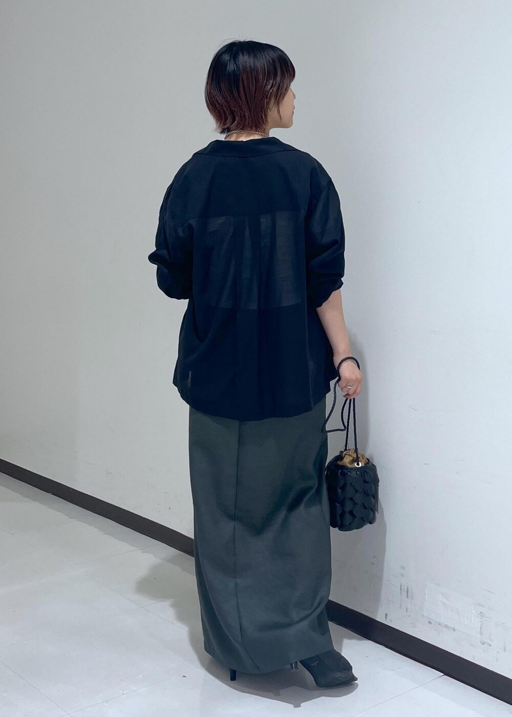 グレー系のスカート、ブラック系のテーラードジャケット、ホワイト系のTシャツ/カットソーを着用したレディースの夏コーディネートの3枚目の写真