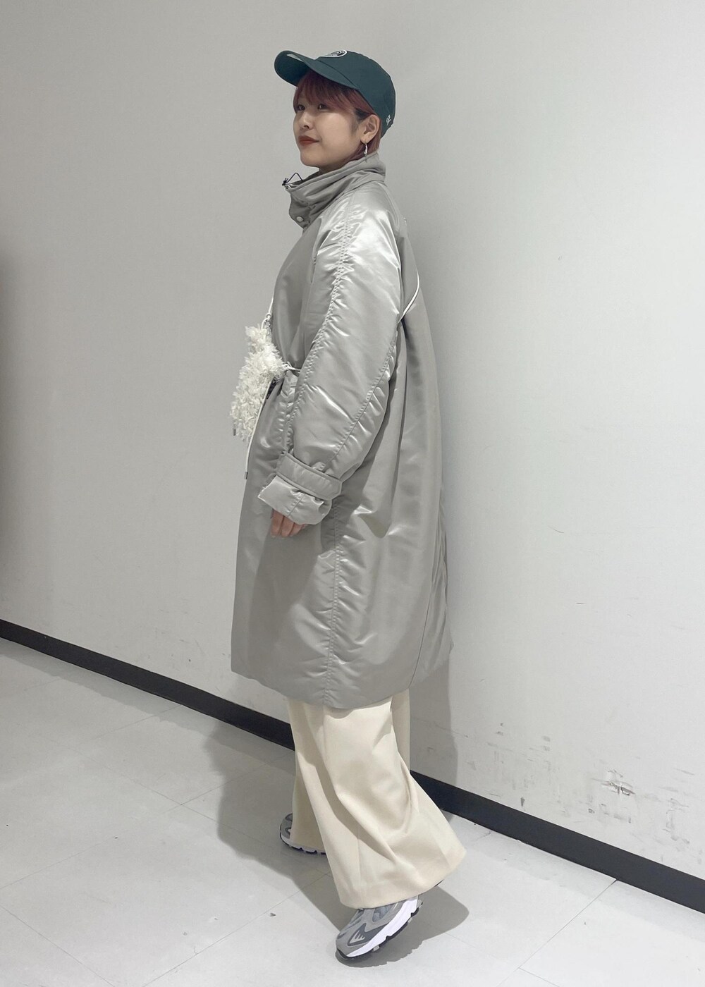 ホワイト系のスラックス、グリーン系のスウェット、ホワイト系のショルダーバッグを着用したレディースの秋コーディネートの2枚目の写真