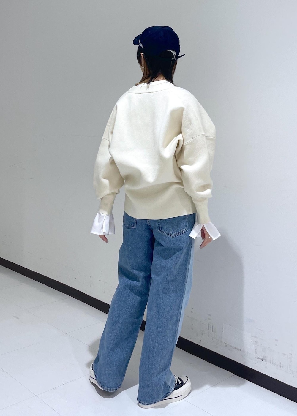 ホワイト系のカーディガン/ボレロ、ブルー系のデニムパンツ、ホワイト系のTシャツ/カットソーを着用したレディースの冬コーディネートの4枚目の写真