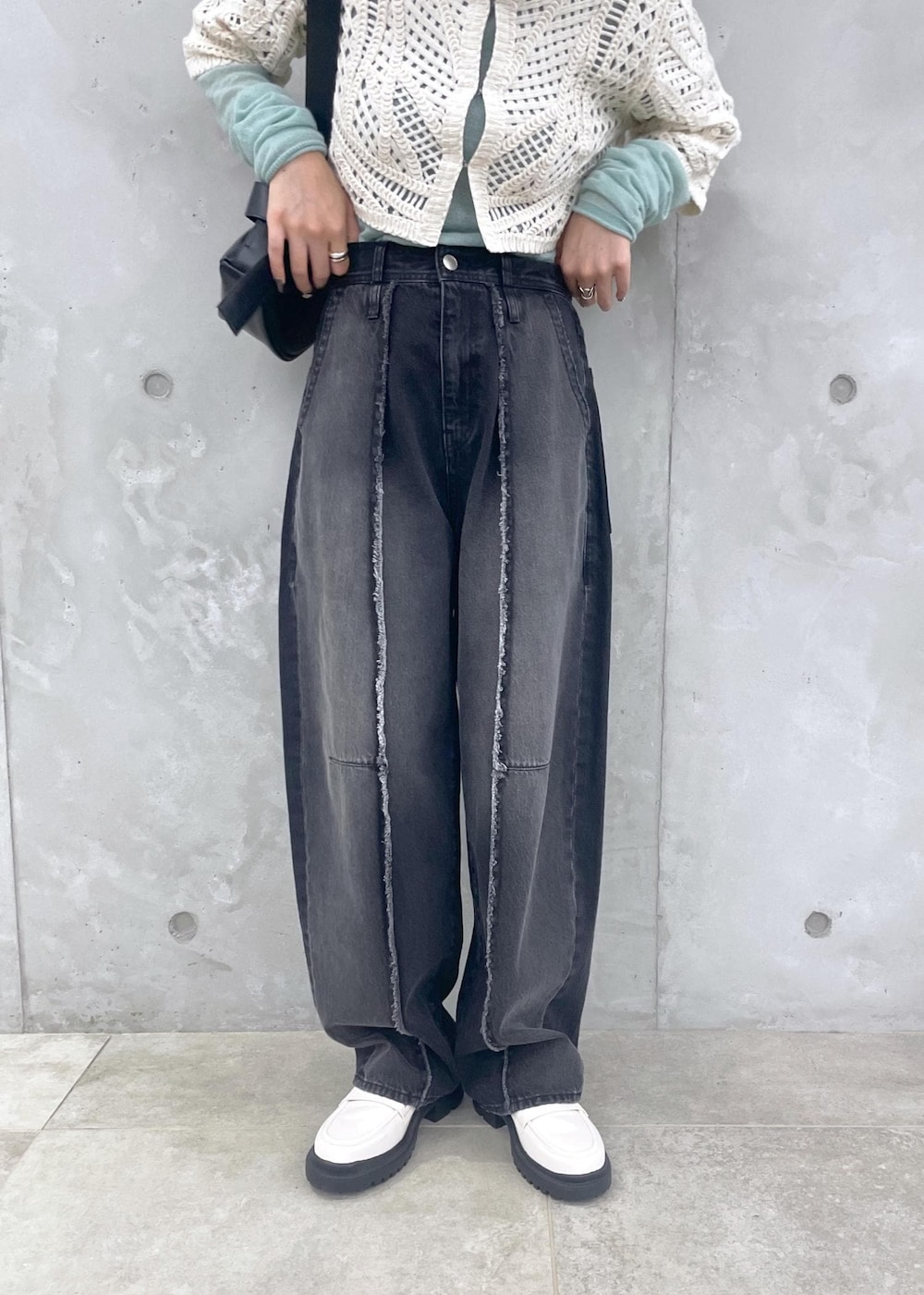 ホワイト系のローファー、グリーン系のニット/セーター、ブラック系のデニムパンツを着用したレディースの冬コーディネートの8枚目の写真