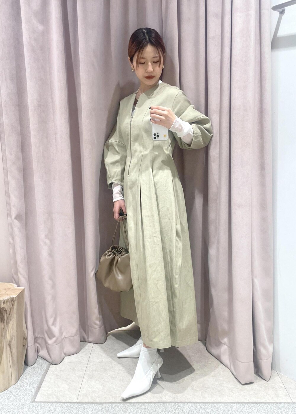 ホワイト系のTシャツ/カットソー、ブラウン系のショルダーバッグ、ホワイト系のパンプスを着用したレディースの冬コーディネートの3枚目の写真