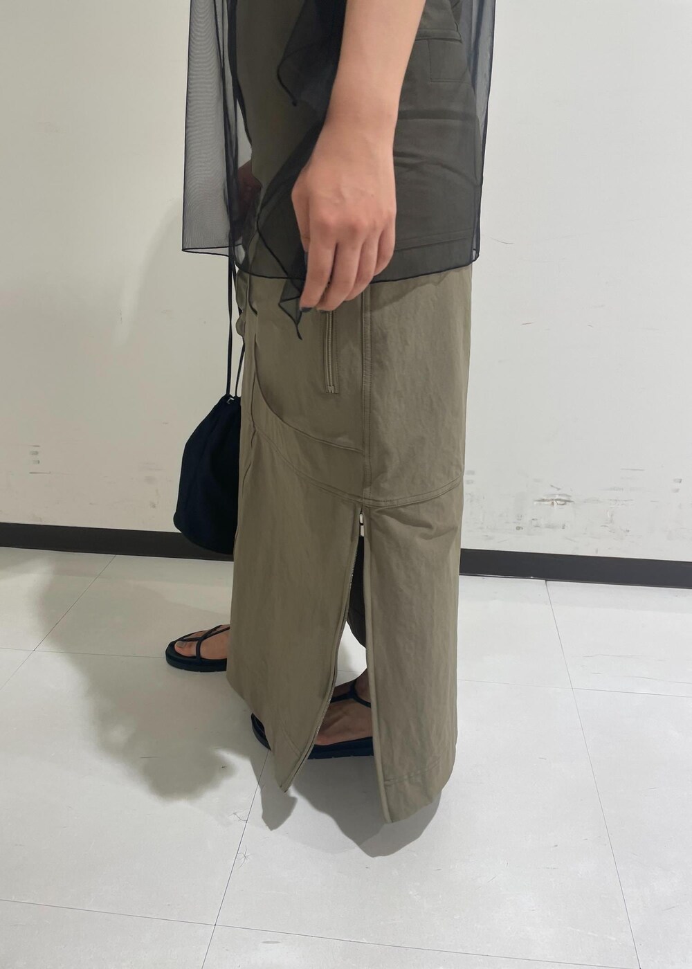 ブラック系のサンダル、ブラック系のショルダーバッグ、ベージュ系のスカートを着用したレディースの夏コーディネートの9枚目の写真