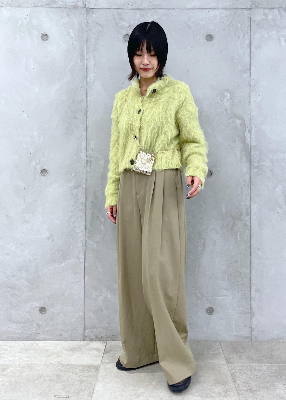 グリーン系のカーディガン/ボレロ、グリーン系のスラックス、ブラウン系のローファーを着用したレディースの秋コーディネートの3枚目の写真