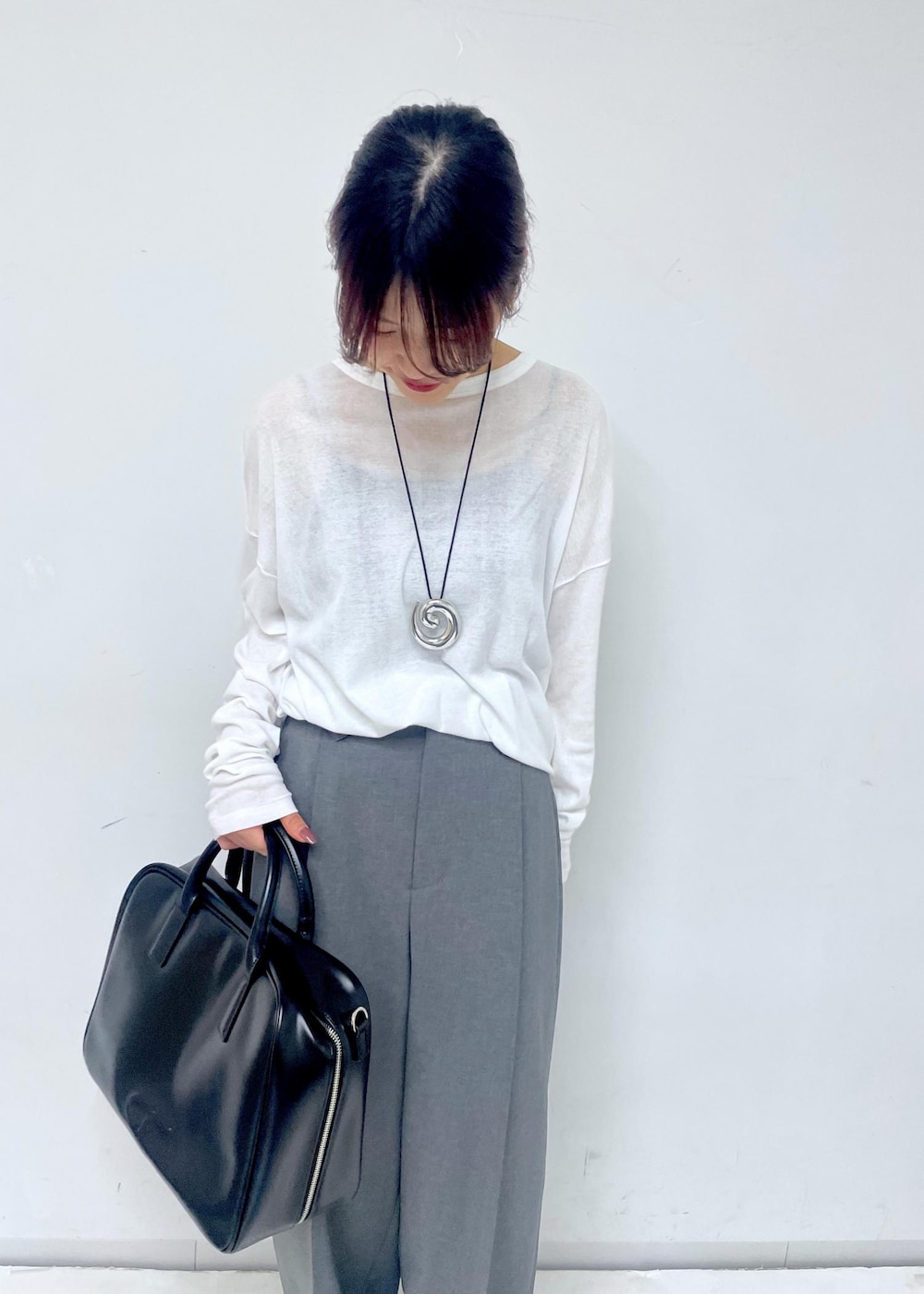 ブラック系のボストンバッグ、シルバー系のサンダル、ホワイト系のTシャツ/カットソーを着用したレディースの春コーディネートの5枚目の写真