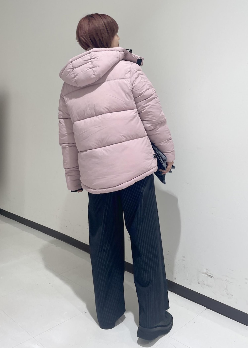 ブラック系のブーツ、ピンク系のダウンジャケット/コート、ブラック系のTシャツ/カットソーを着用したレディースの秋コーディネートの3枚目の写真