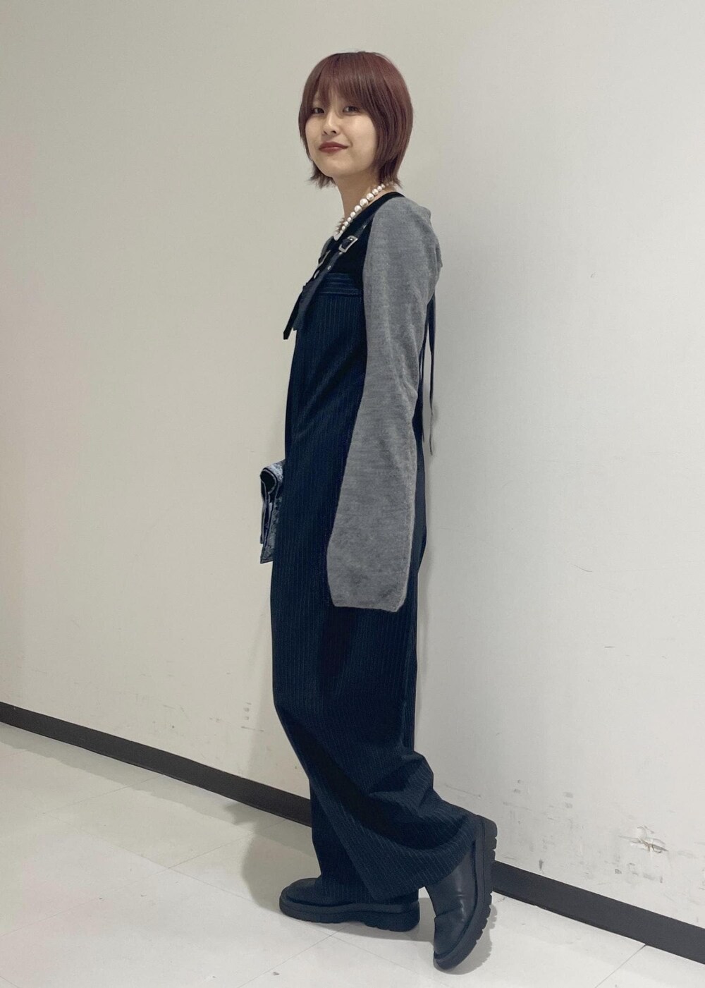 ブラック系のブーツ、ブラック系のTシャツ/カットソー、グレー系の手袋を着用したレディースの秋コーディネートの2枚目の写真