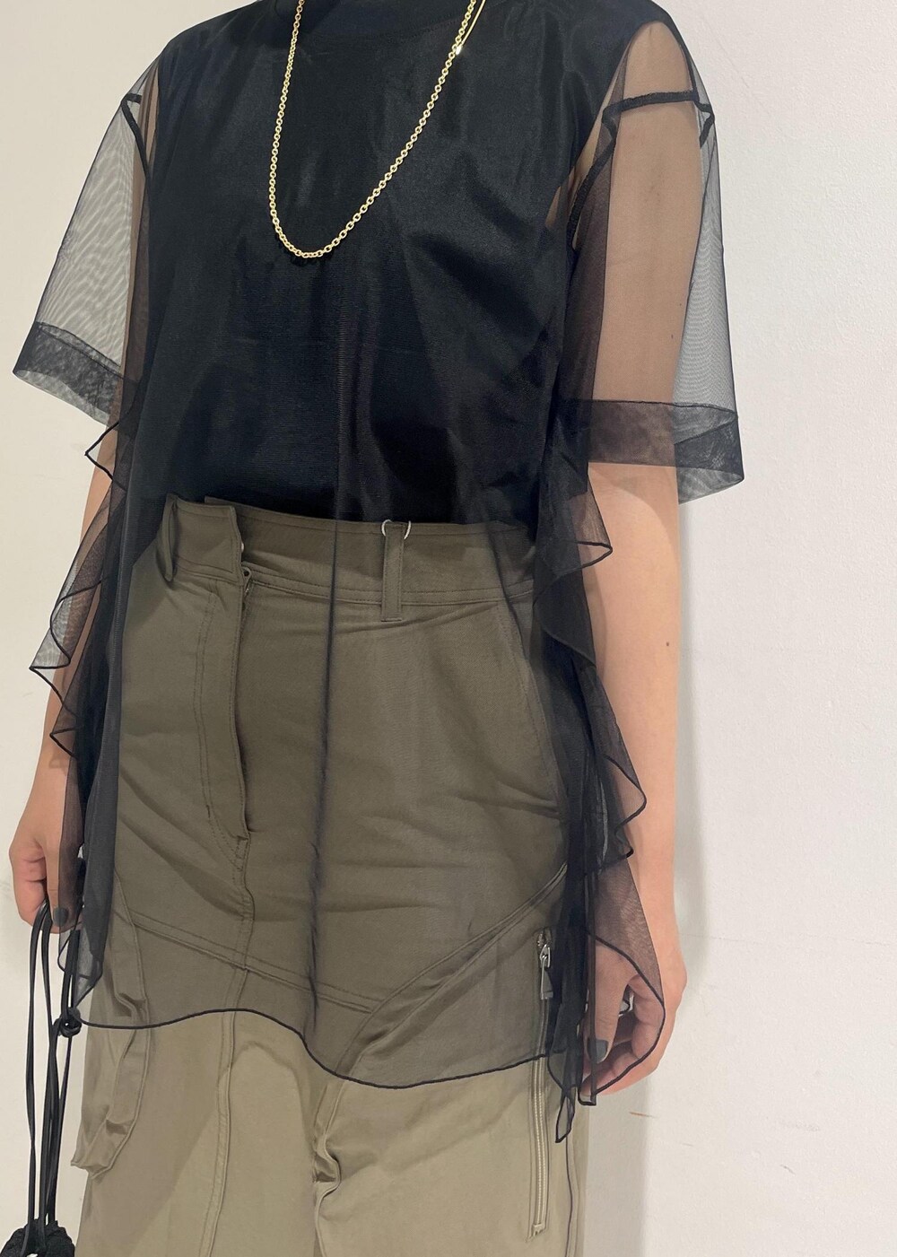 ブラック系のサンダル、ブラック系のショルダーバッグ、ベージュ系のスカートを着用したレディースの夏コーディネートの7枚目の写真