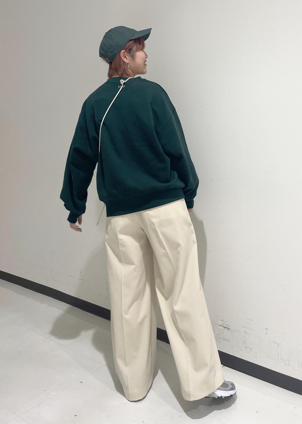 ホワイト系のスラックス、グリーン系のスウェット、ホワイト系のショルダーバッグを着用したレディースの秋コーディネートの3枚目の写真