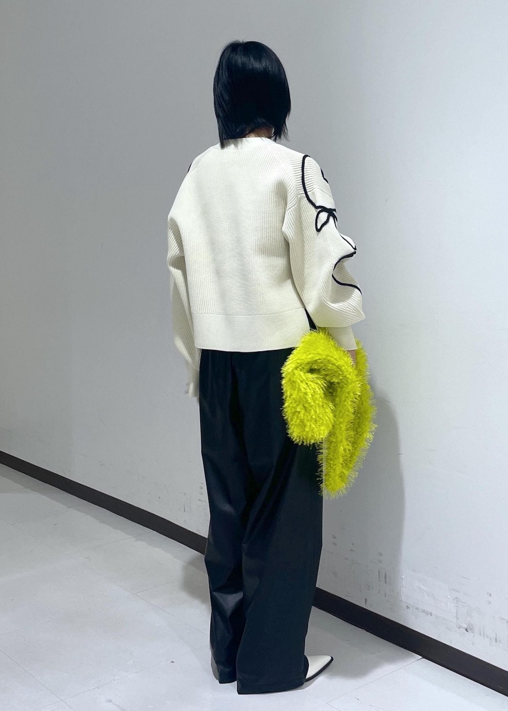 ホワイト系のパンプス、ホワイト系のカーディガン/ボレロ、グリーン系のハンドバッグを着用したレディースの秋コーディネートの4枚目の写真