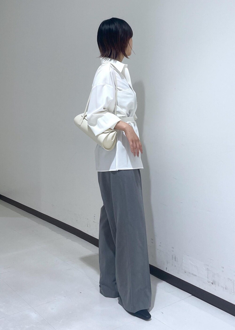 ホワイト系のシャツ/ブラウス、ホワイト系のショルダーバッグ、グレー系のスラックスを着用したレディースの夏コーディネートの6枚目の写真