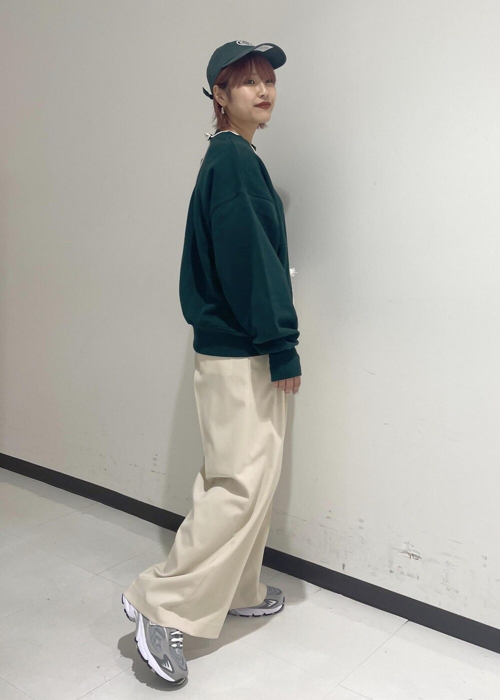 ホワイト系のスラックス、グリーン系のスウェット、ホワイト系のショルダーバッグを着用したレディースの秋コーディネートの4枚目の写真