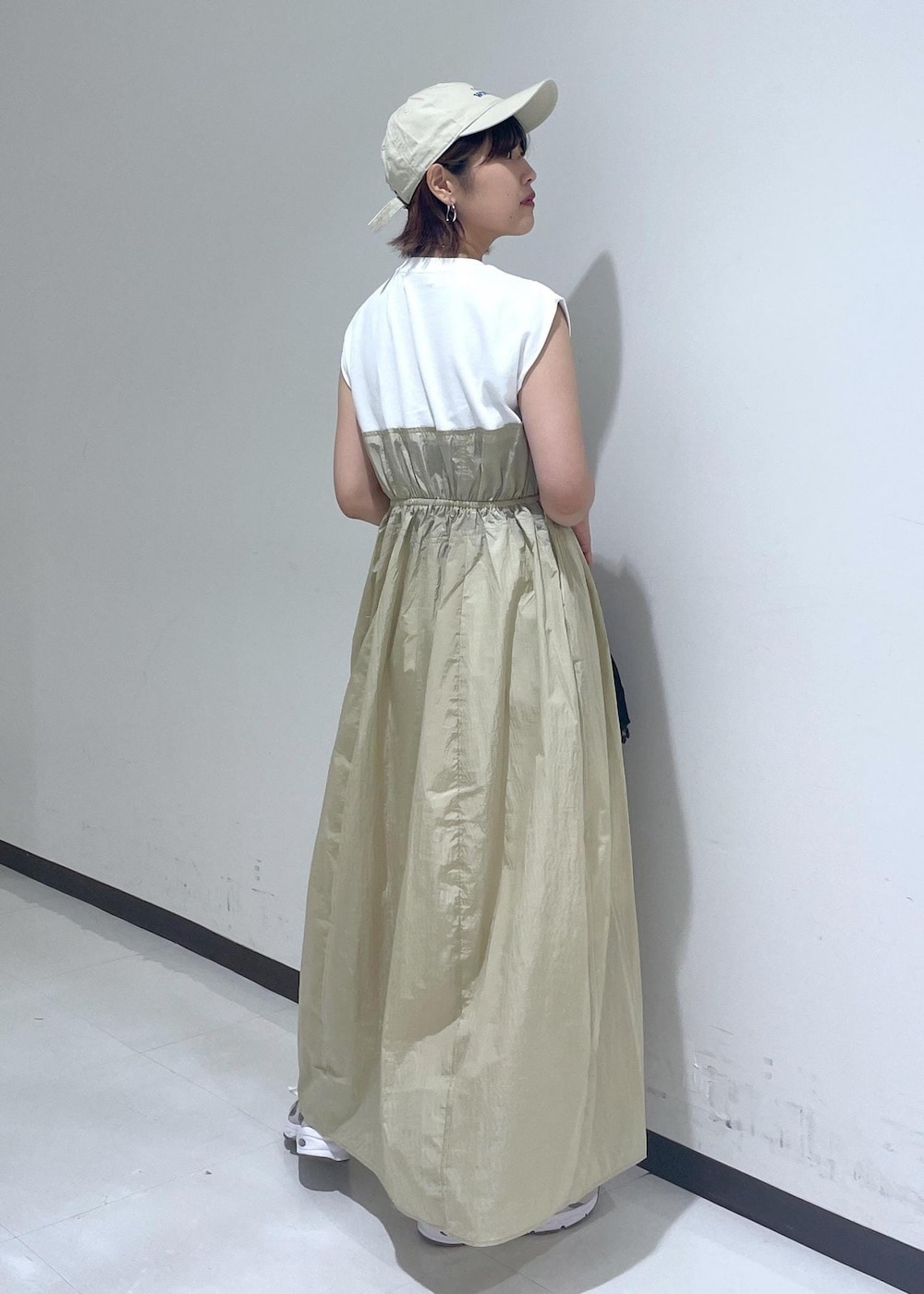 ブラウン系のハンドバッグ、ベージュ系のワンピース、ホワイト系のネックレスを着用したレディースの夏コーディネートの4枚目の写真