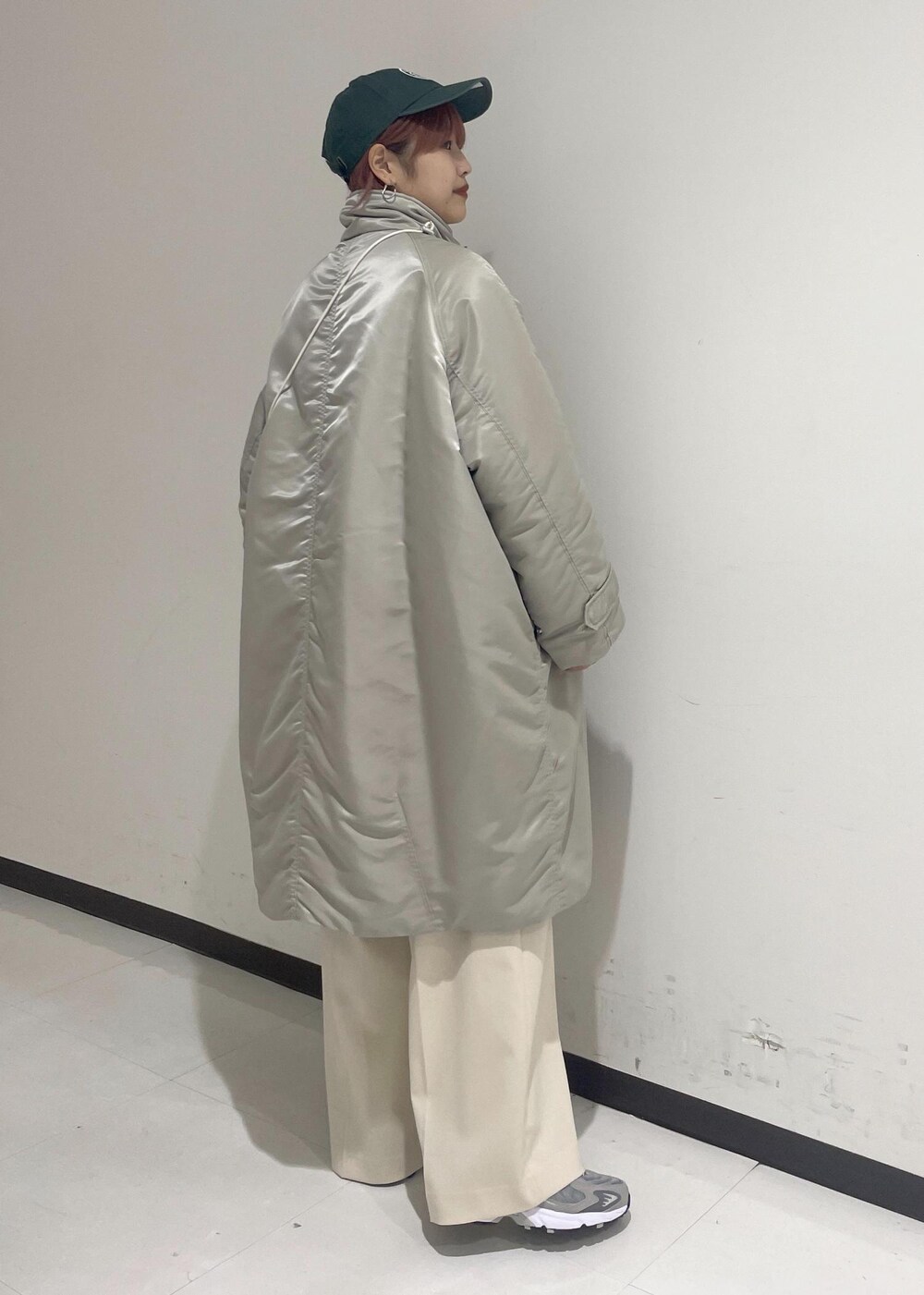 ホワイト系のスラックス、グリーン系のスウェット、ホワイト系のショルダーバッグを着用したレディースの秋コーディネートの4枚目の写真