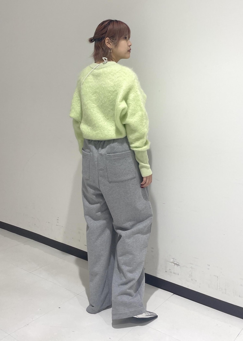 シルバー系のパンプス、グリーン系のニット/セーター、ホワイト系のショルダーバッグを着用したレディースの秋コーディネートの3枚目の写真