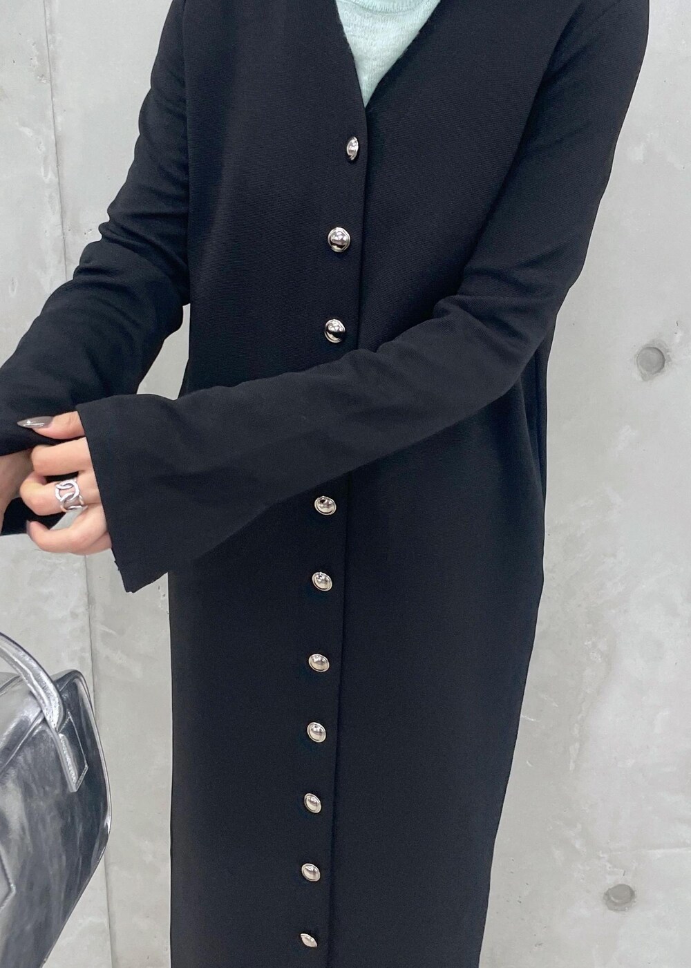 ブラック系のローファー、グリーン系のニット/セーター、シルバー系のショルダーバッグを着用したレディースの冬コーディネートの10枚目の写真