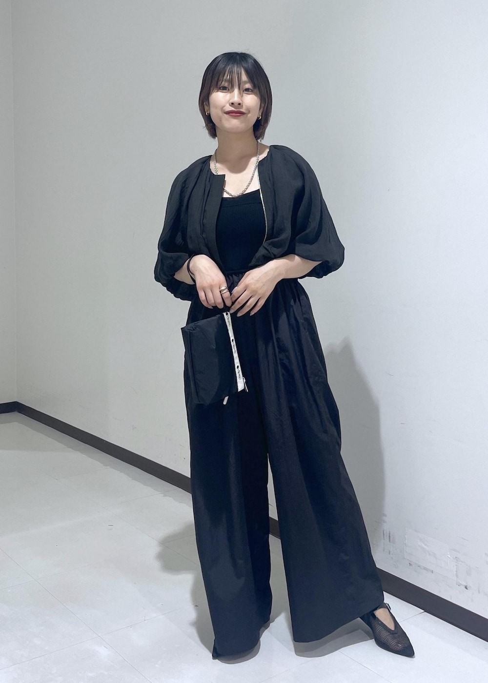 ブラック系のパンプス、ブラック系のシャツ/ブラウス、ブラック系のつなぎ/オールインワンを着用したレディースの夏コーディネートの2枚目の写真