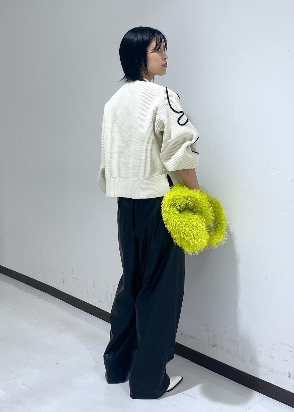 ホワイト系のパンプス、ホワイト系のカーディガン/ボレロ、グリーン系のハンドバッグを着用したレディースの秋コーディネートの5枚目の写真