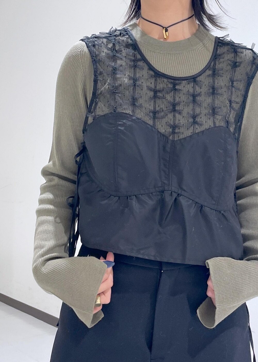 ブラック系のブーツ、グリーン系のニット/セーター、イエロー系のハンドバッグを着用したレディースの秋コーディネートの5枚目の写真