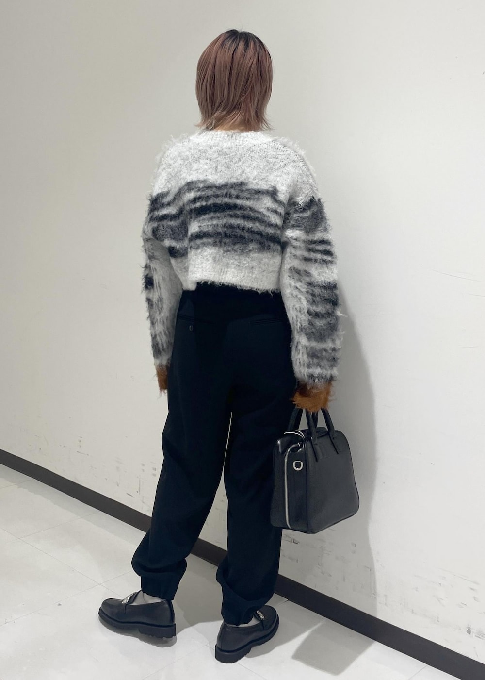 ブラック系のボストンバッグ、ブラック系のローファーを着用したレディースの冬コーディネートの3枚目の写真