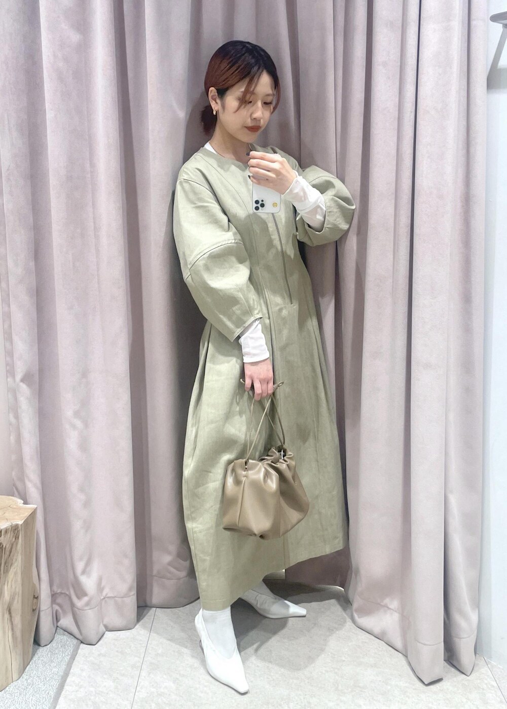 ホワイト系のTシャツ/カットソー、ブラウン系のショルダーバッグ、ホワイト系のパンプスを着用したレディースの冬コーディネートの2枚目の写真