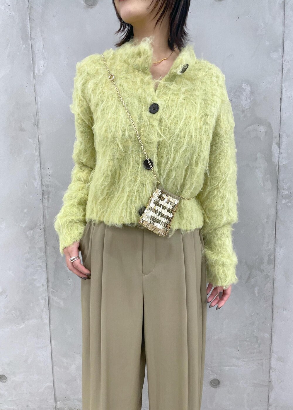 グリーン系のカーディガン/ボレロ、グリーン系のスラックス、ブラウン系のローファーを着用したレディースの秋コーディネートの6枚目の写真