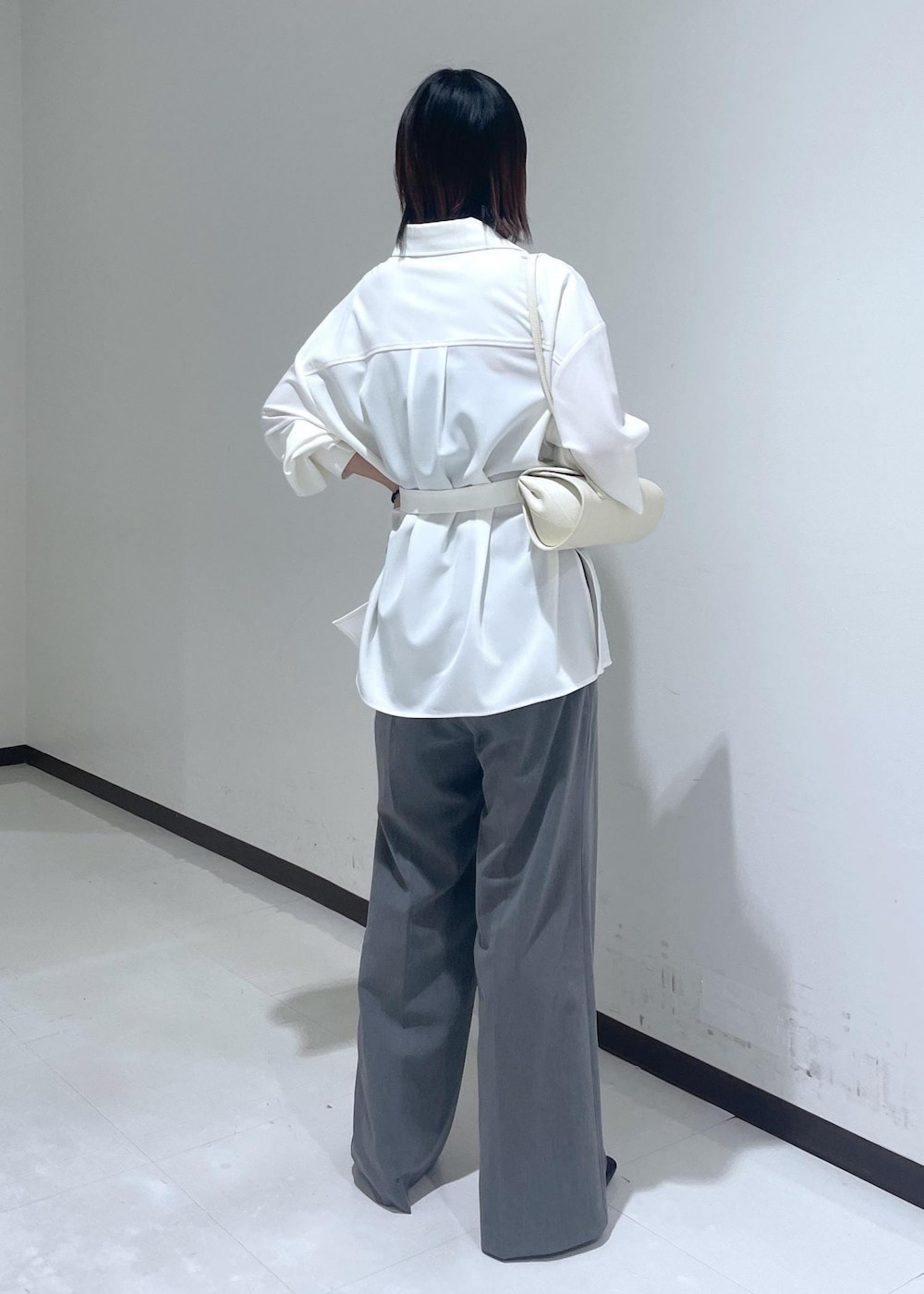ホワイト系のシャツ/ブラウス、ホワイト系のショルダーバッグ、グレー系のスラックスを着用したレディースの夏コーディネートの4枚目の写真