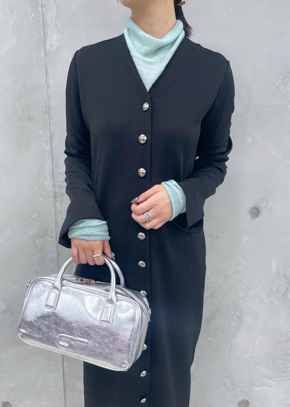 ブラック系のローファー、グリーン系のニット/セーター、シルバー系のショルダーバッグを着用したレディースの冬コーディネートの8枚目の写真