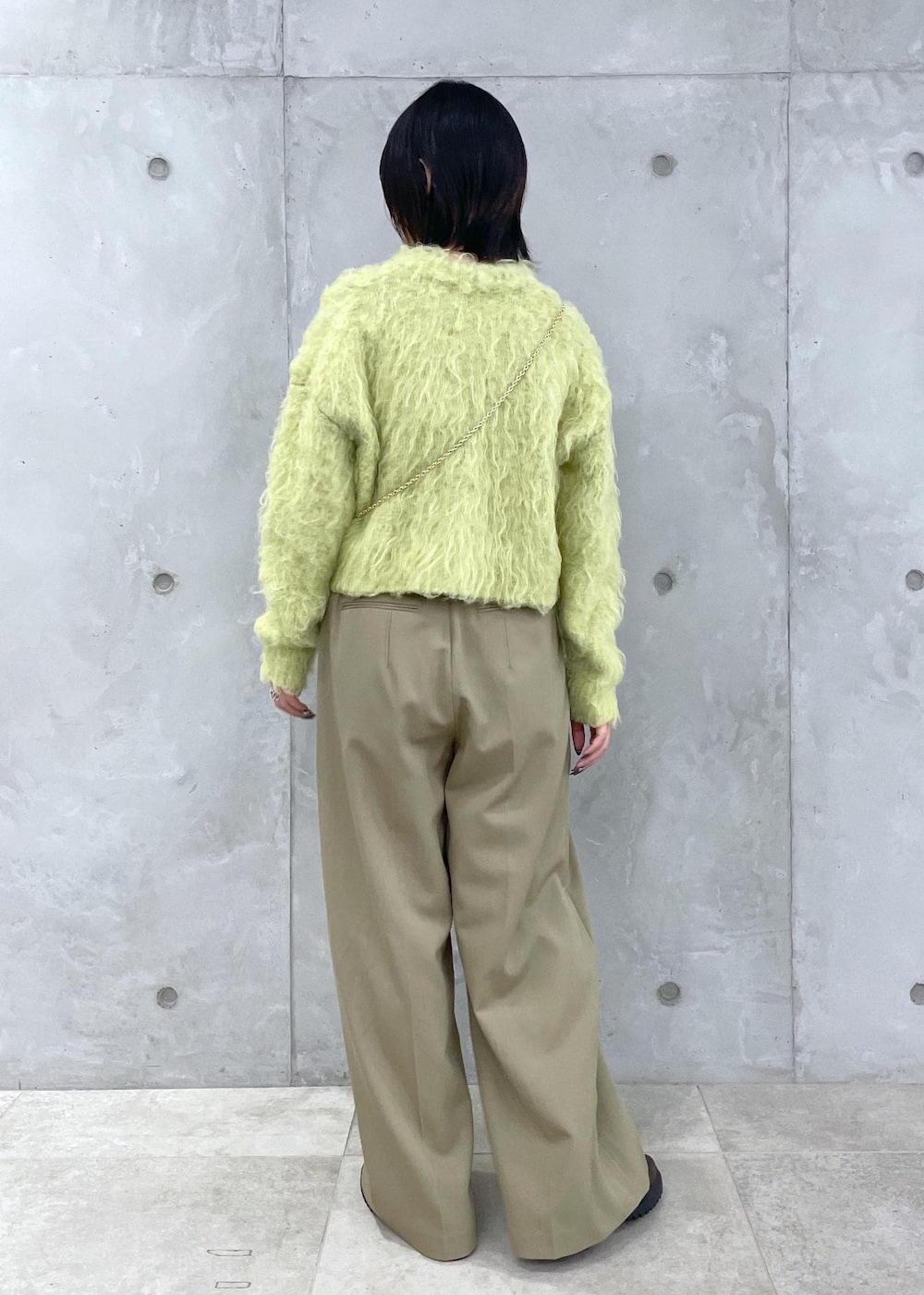 グリーン系のカーディガン/ボレロ、グリーン系のスラックス、ブラウン系のローファーを着用したレディースの秋コーディネートの4枚目の写真