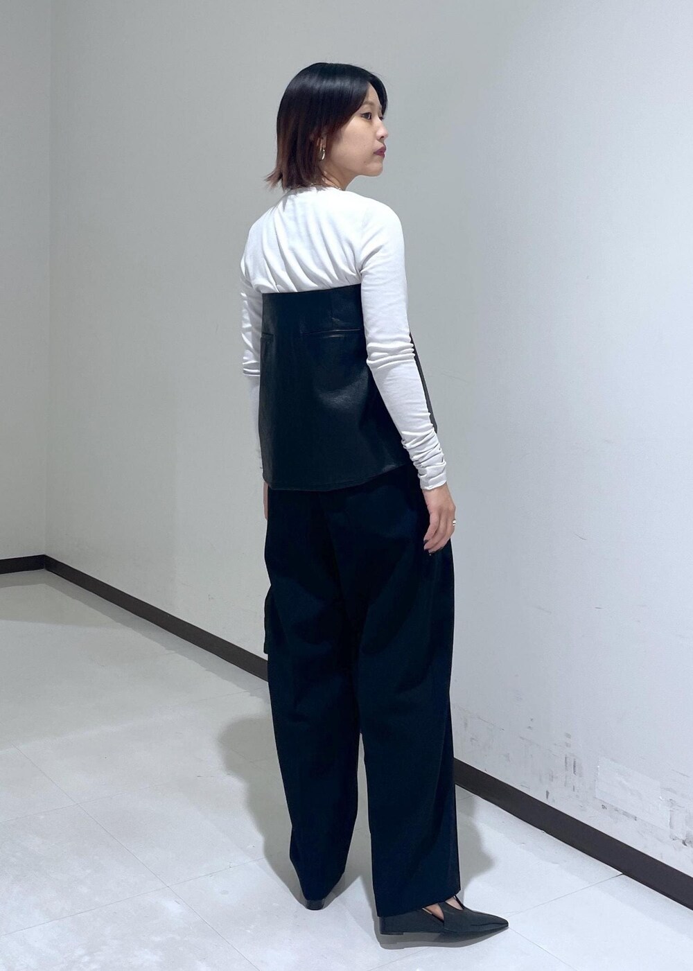 ブラック系のハンドバッグ、グレー系のTシャツ/カットソー、ブラック系のパンプスを着用したレディースの夏コーディネートの5枚目の写真