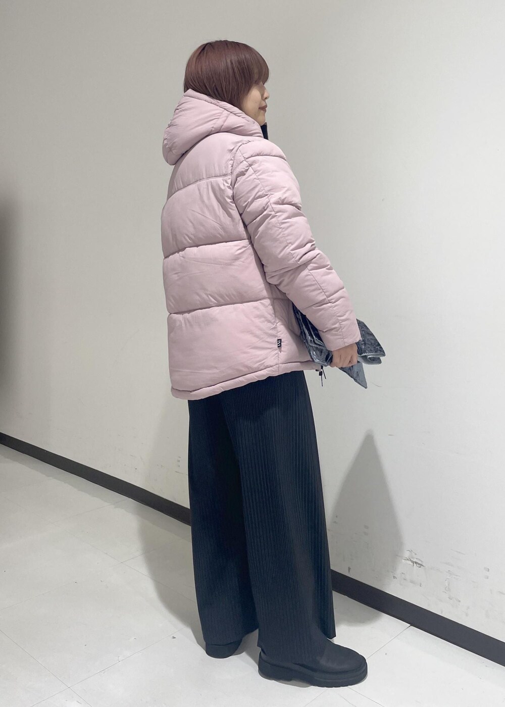 ブラック系のブーツ、ピンク系のダウンジャケット/コート、ブラック系のTシャツ/カットソーを着用したレディースの秋コーディネートの4枚目の写真